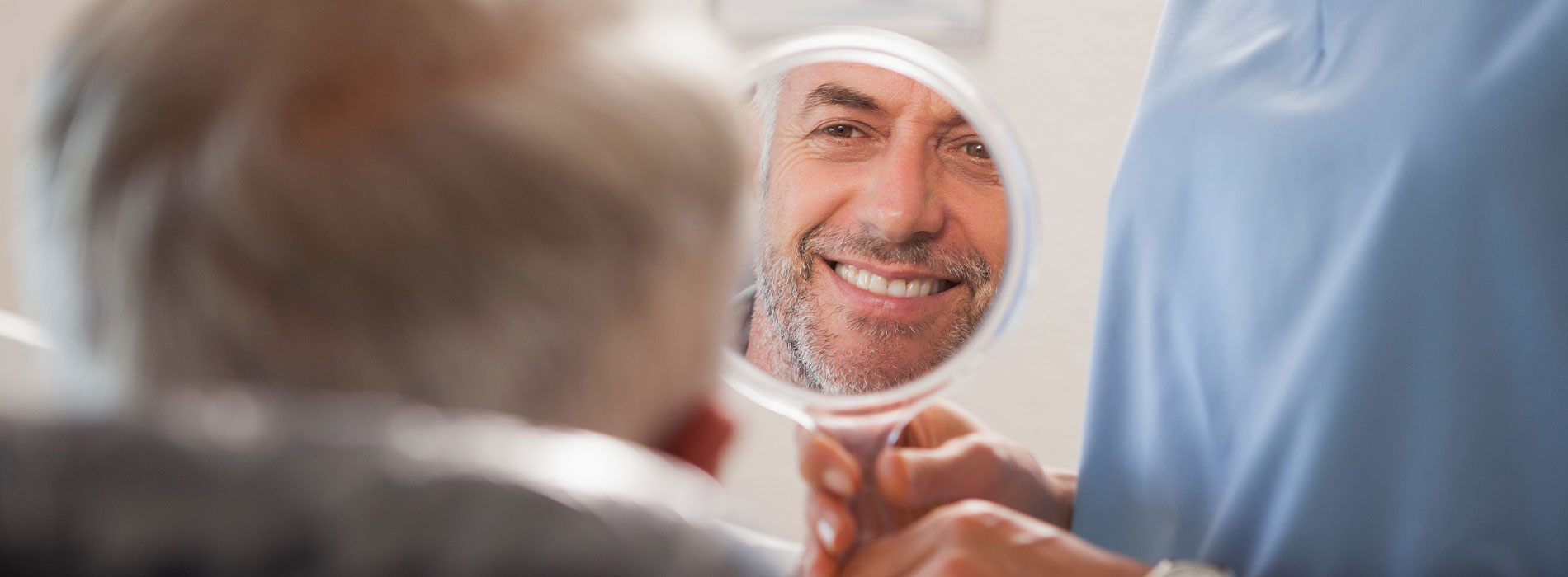 A well-lit reception area with a desk, computer monitor, and potted plant.